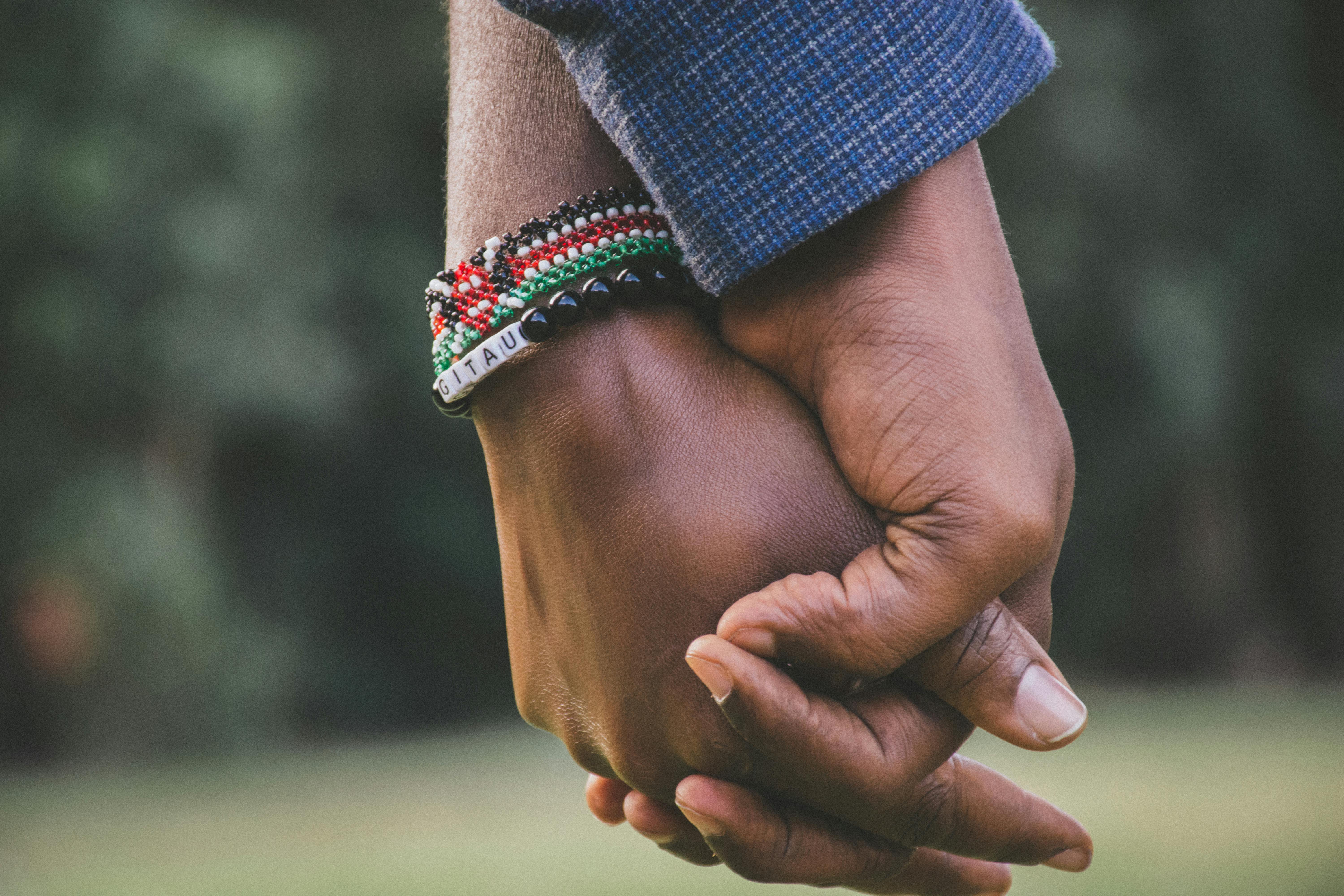 A close-up view of a couple holding hands, symbolizing love and togetherness.