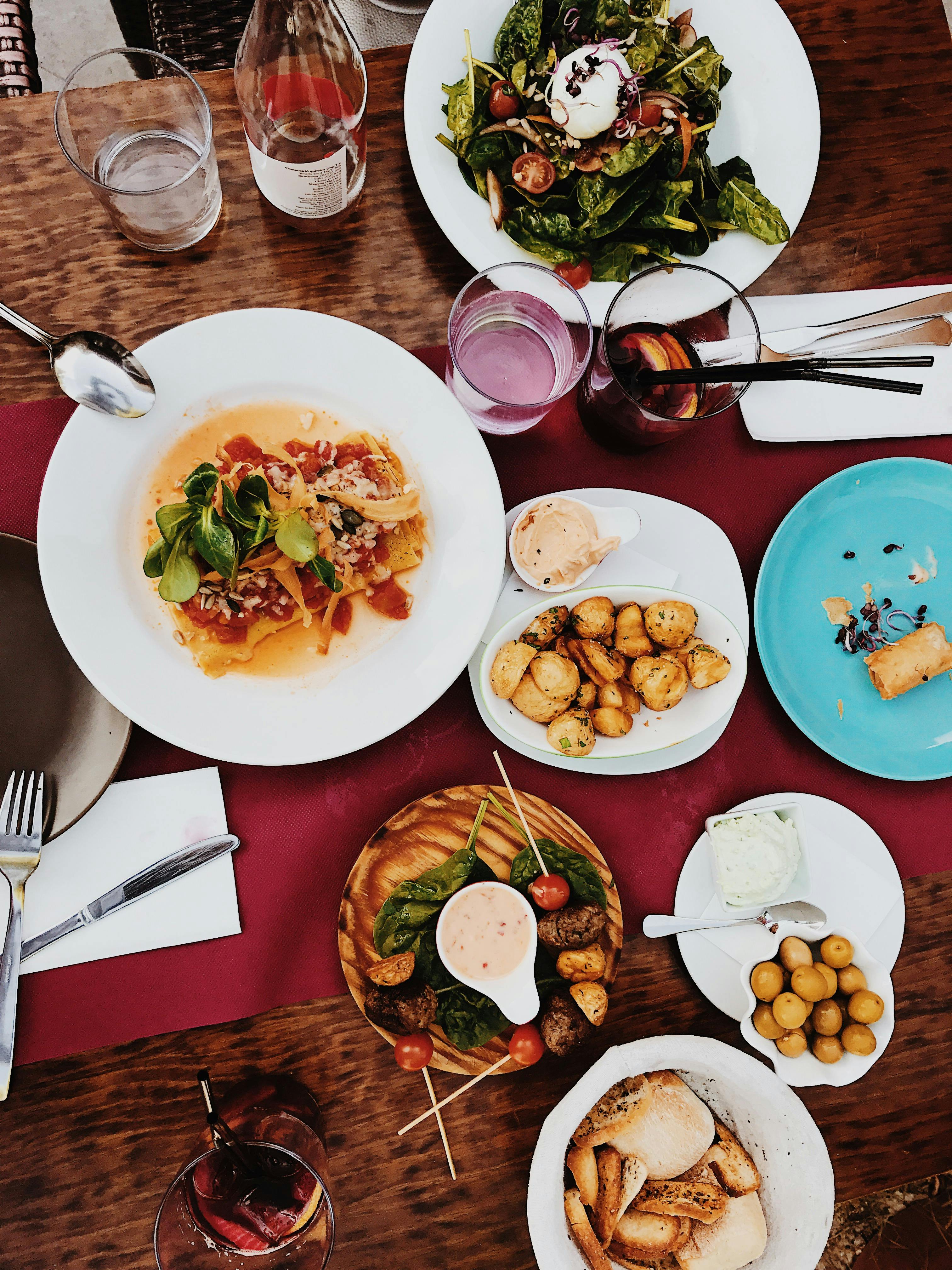 A colorful spread of gourmet dishes on a classy dinner table setting.