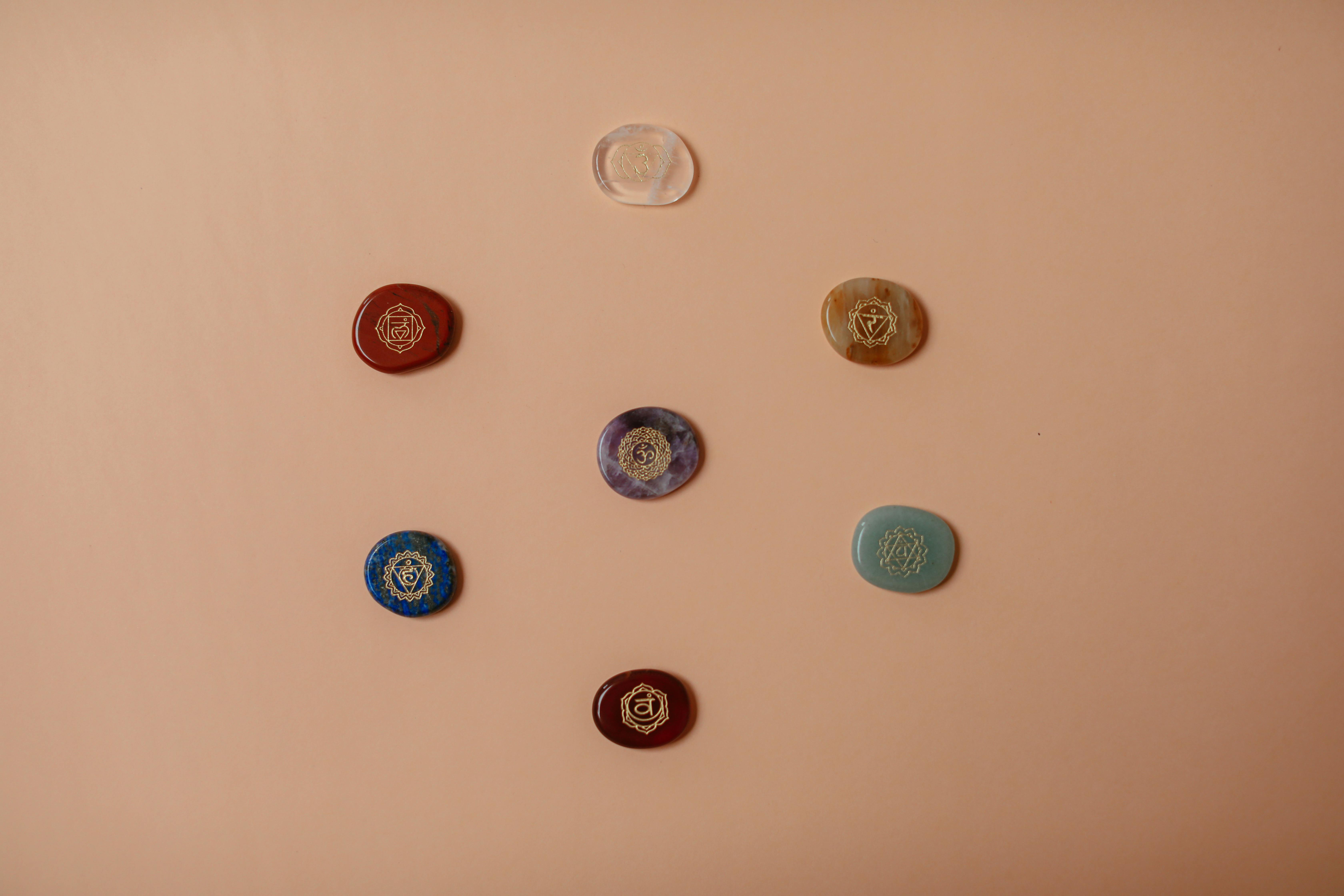 Flat lay of colorful chakra stones arranged on a brown surface, perfect for meditation.