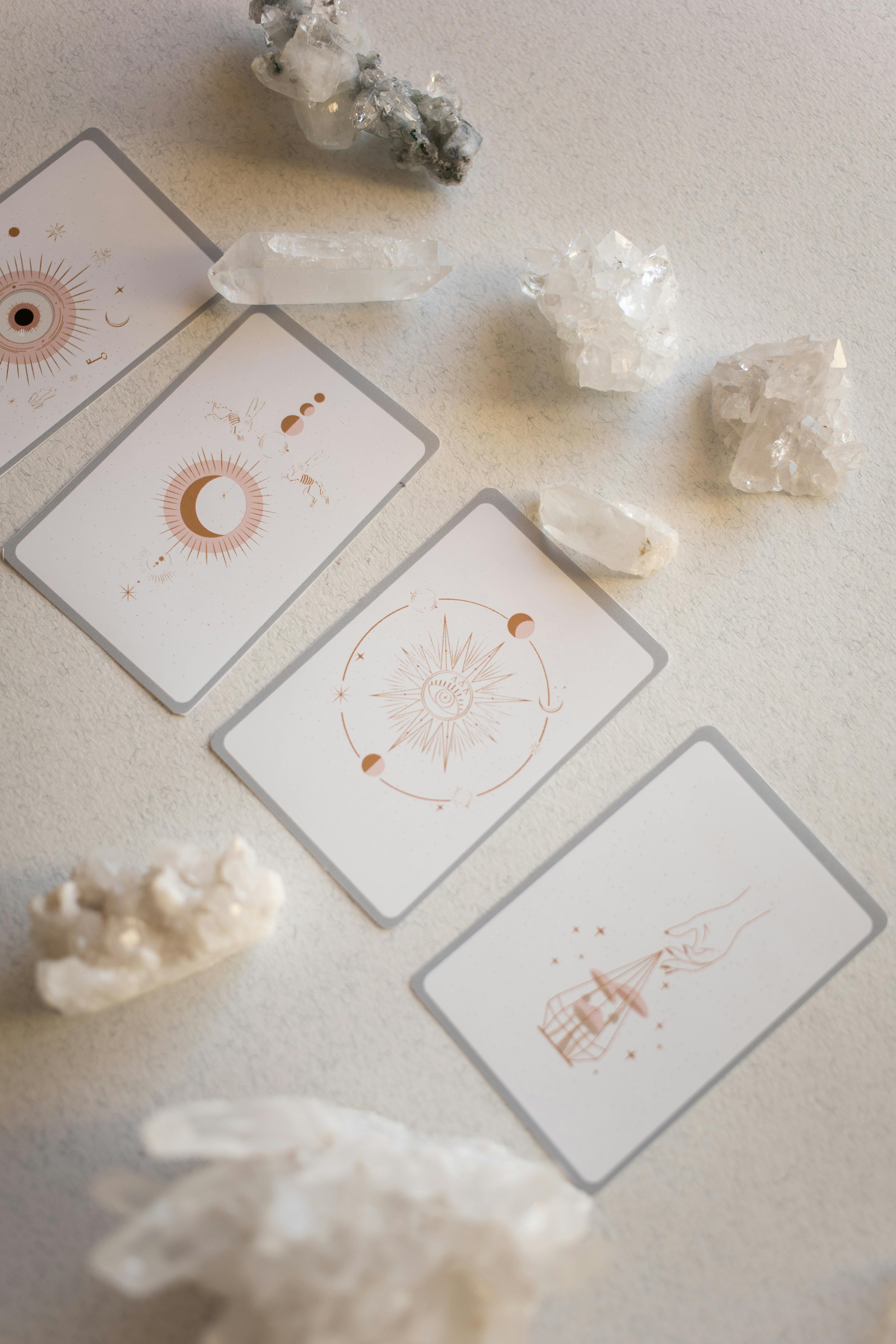 A top-down view of tarot cards and crystals arranged on a neutral background, evoking a mystical atmosphere.