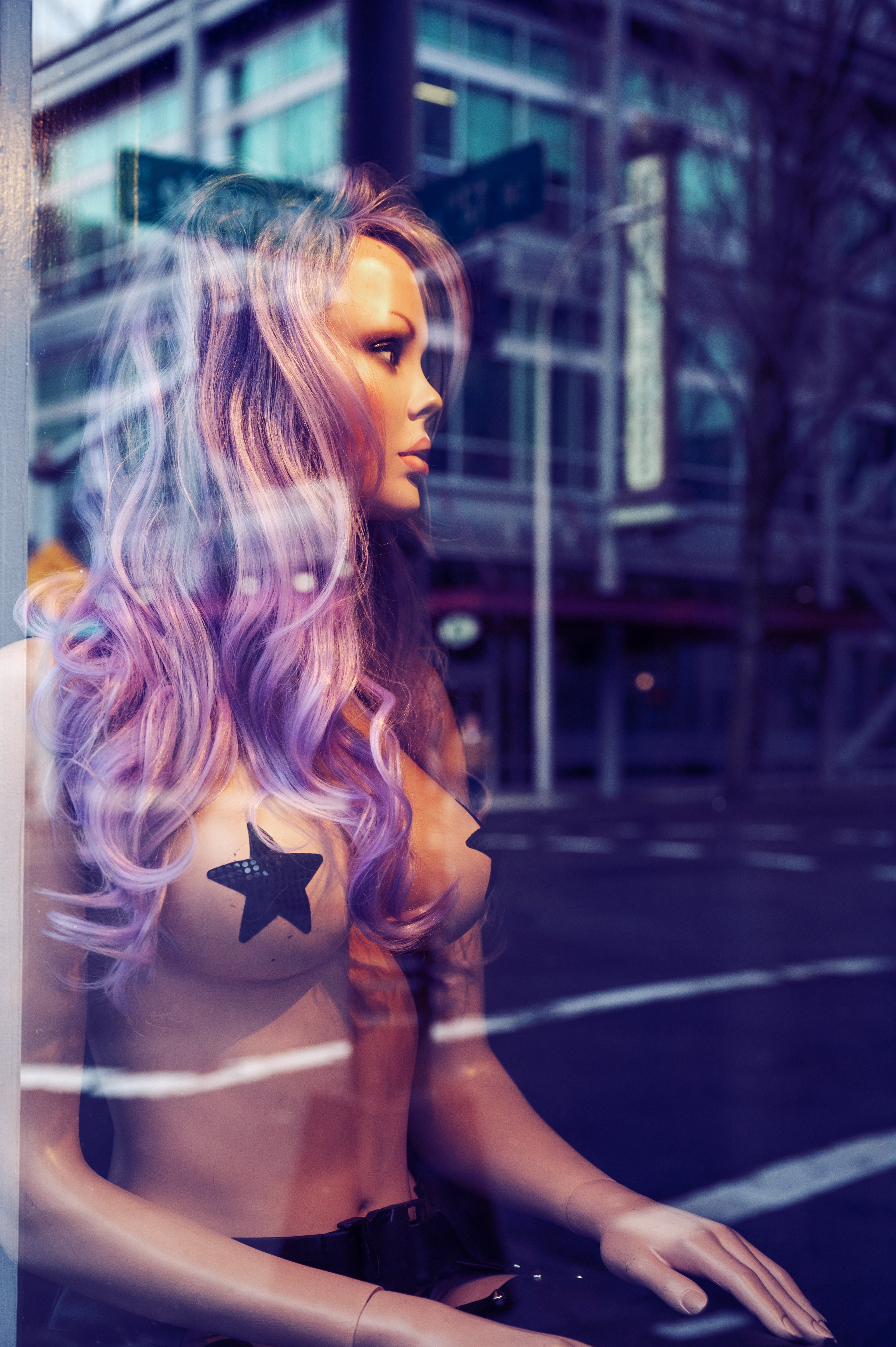 Mannequin with purple hair and star stickers in a Portland shop window.