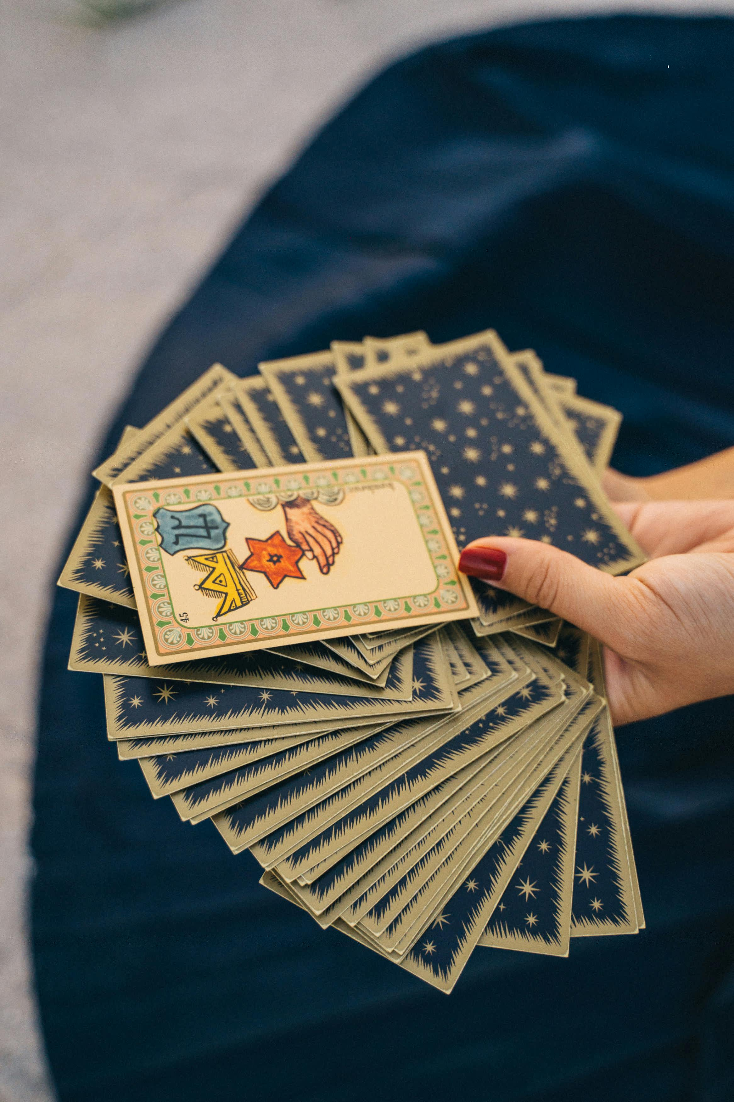 A hand holding a spread of tarot cards, symbolizing mysticism and spirituality.