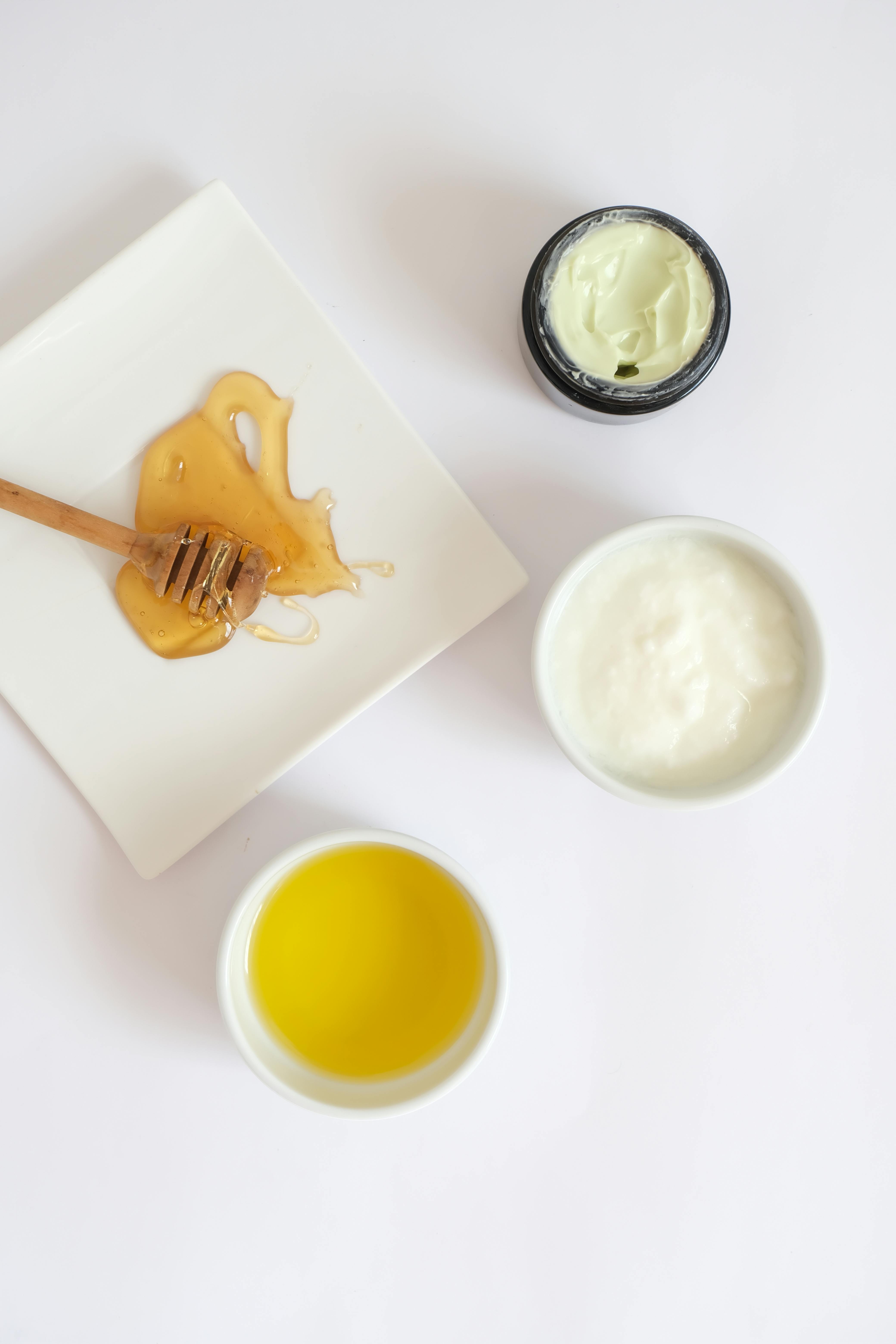 Flat lay of honey, yogurt, and cream for DIY beauty treatments.